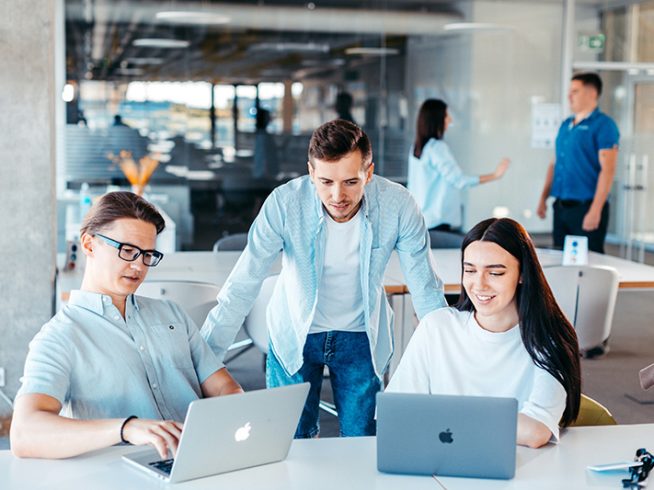 A team of IT professionals collaborates in a modern office, strategizing technology solutions for business efficiency.